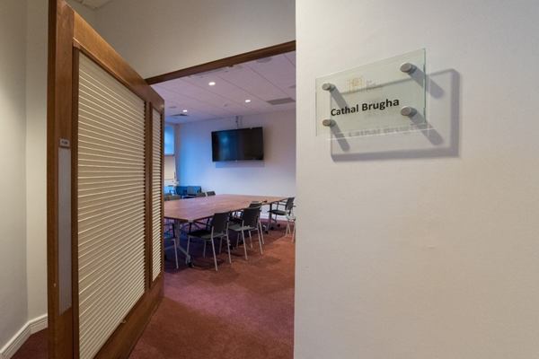 Image of Cathal Brugha Room and its door. This image shows the Cathal Brugha room and the swinging door to either enter or exit the room. To enter you need to pull the door towards reception and enter through the widest part of the opening. To exit you need to push the door towards the reception and leave through the widest part of the opening.