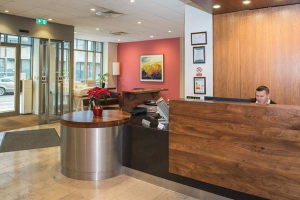 Reception desk. This image shows the reception desk and the receptionist sat behind the desk. The desk is accessible. There is always at least one receptionist and normally there are two.